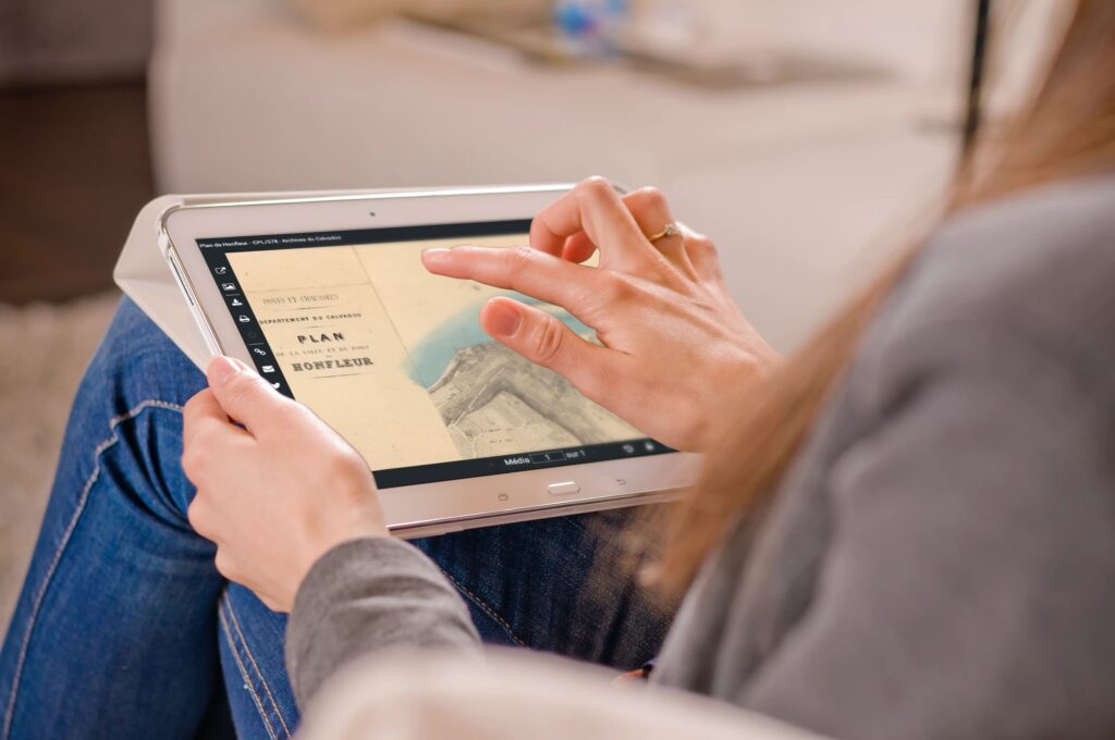 femme en train d'utiliser une tablette pour consulter un cadastre sur un portail d'archives