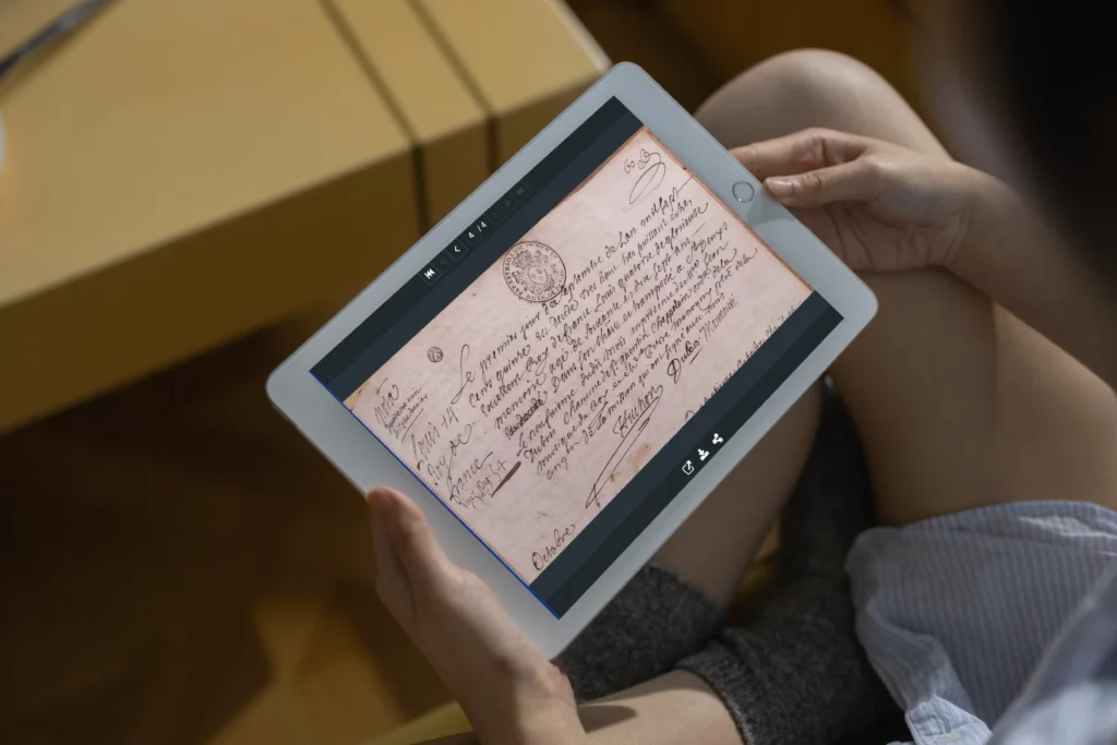 Personne sur sa tablette qui consulte l'acte de décès de Louis XIV sur le site des Archives municipales de Versailles