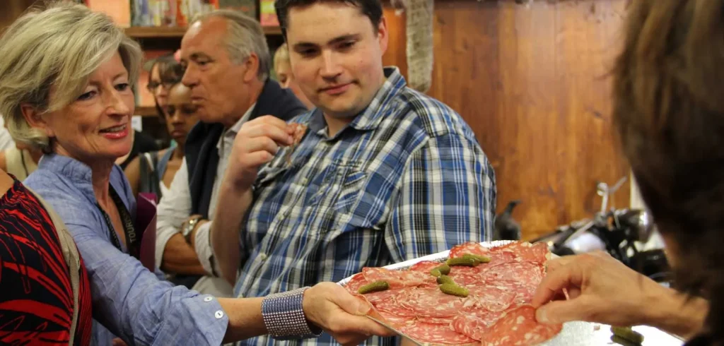 Personnes en train de déguster de la charcuterie lyonnaise.